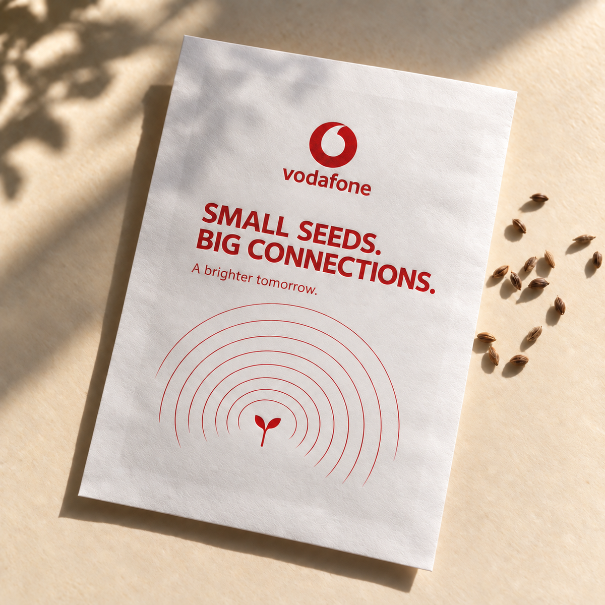 Vodafone seed favour with red artwork inside white print margins, photographed in natural sunlight